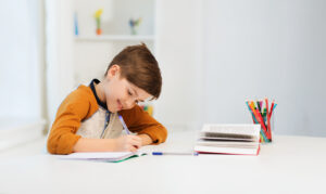 Estudante sorridente estudando em casa.