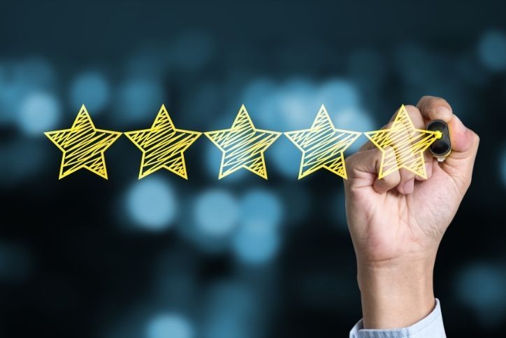 Mão desenhando cinco estrelas.