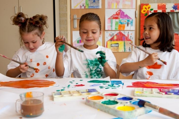 professor e alunos com instrumentos musicais em frente a um quadro com notas musicais.