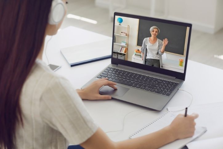 jovem estudante assiste uma videoaula em um notebook.